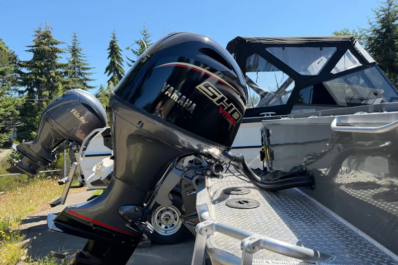 Slide: The Image of A 2026 Hewescraft 180 ProV Hard Top with a Yamaha outboard motor, surrounded by trees. - 3