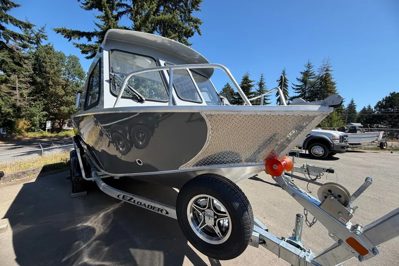 The Image of A 2026 Hewescraft 180 ProV Hard Top on a trailer, surrounded by trees. - 1