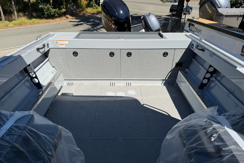 Slide: The Image of The image shows the spacious stern of a Hewescraft 180 ProV Hard Top boat with gray flooring. - 9