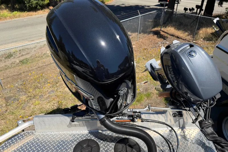 Slide: The Image of Two outboard motors on a boat, surrounded by a fence and trees. - 10