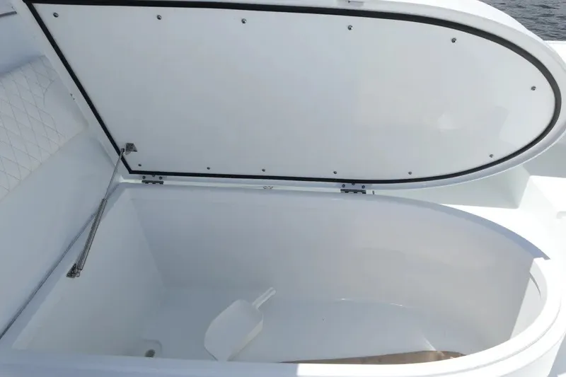 Slide: The Image of Open storage compartment on 2022 Freeman 34VH boat, featuring a white interior and lid. - 40