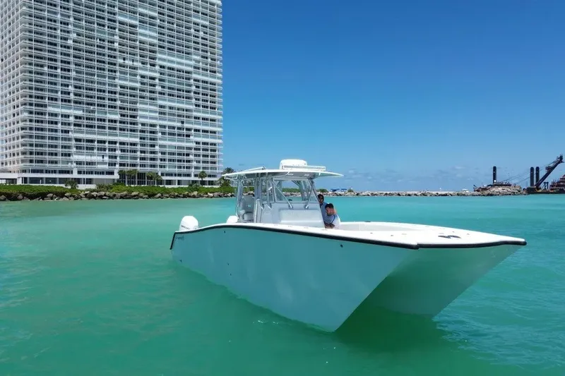 Slide: The Image of Freeman 34VH boat on turquoise water near a high-rise building, 2022 model. - 4