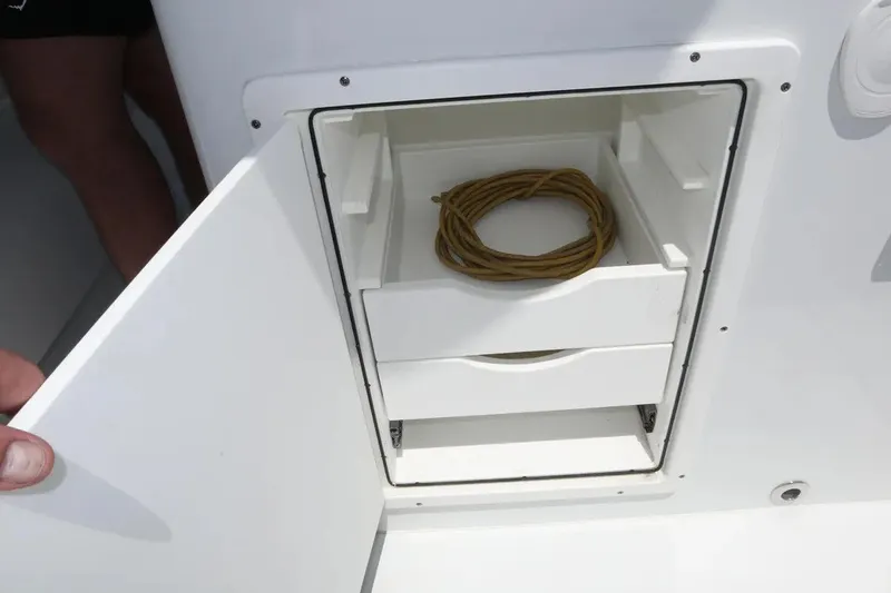 Slide: The Image of Open storage compartment on Freeman 34VH 2022 boat, featuring drawers and coiled rope. - 44