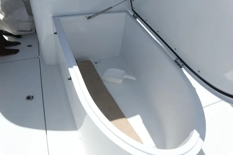 Slide: The Image of Open storage compartment on Freeman 34VH boat, 2022 model, with a white scoop inside. - 38