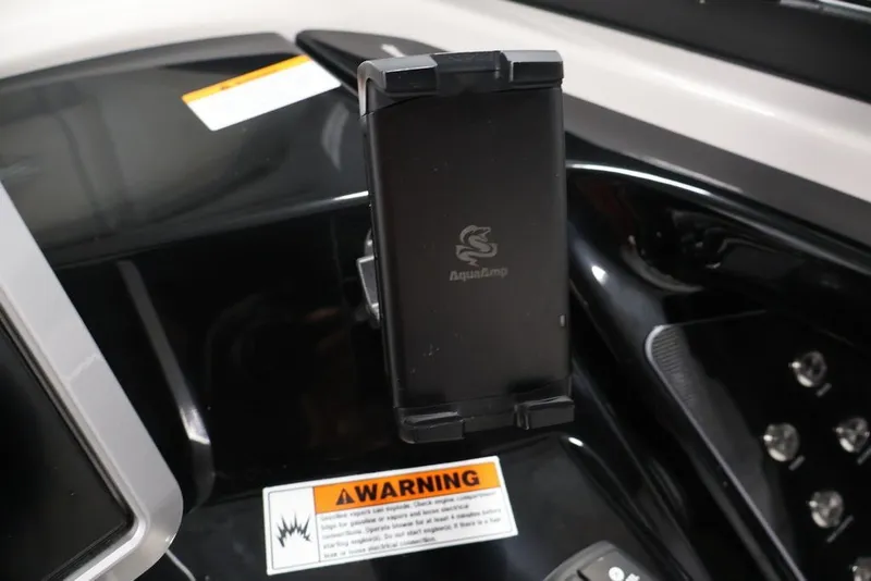 Slide: The Image of Dashboard of 2026 Yamaha Boats 252SD featuring a phone holder and warning label. - 17