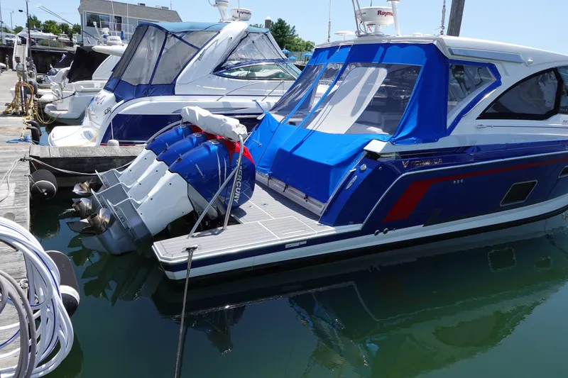 Slide: The Image of 2022 Formula 380 Super Sport Crossover OB docked with blue canopy and Mercury outboard engines. - 2
