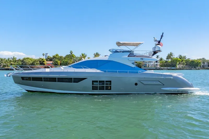 Slide: The Image of 2018 Azimut S7 yacht cruising on a sunny day, surrounded by lush greenery. - 8