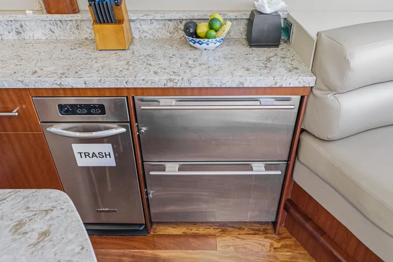 Slide: The Image of Luxury yacht kitchen with stainless steel trash compactor, granite countertop, and fruit bowl. Lazzara 84 Flybridge 2006. - 57