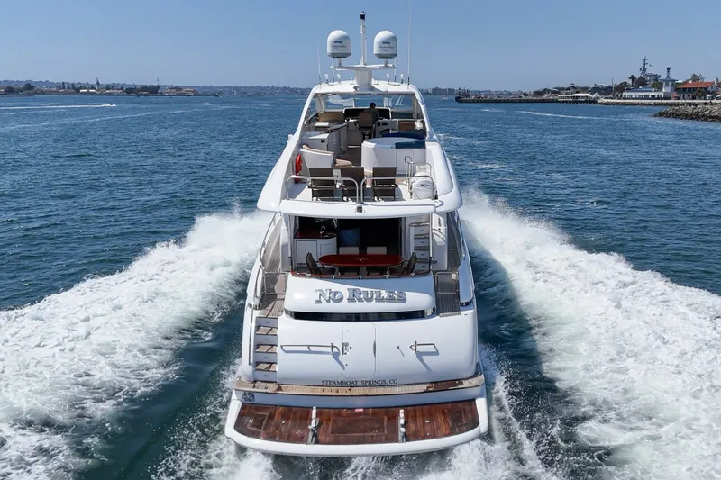 Slide: The Image of Luxury 2006 Lazzara 84 Flybridge yacht cruising on open water, rear view. - 2