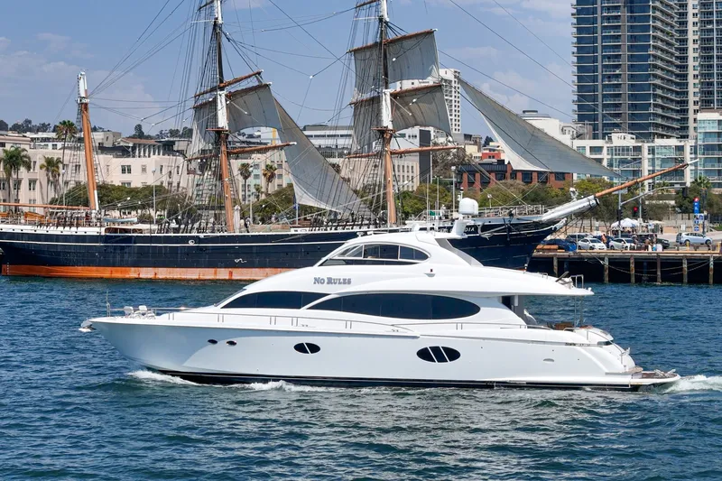 Slide: The Image of 2006 Lazzara 84 Flybridge yacht cruising near historic sailing ship in urban harbor. - 19