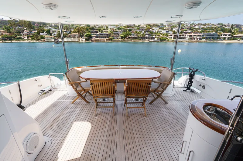 Slide: The Image of Luxurious 2006 Lazzara 84 Flybridge yacht deck with seating, overlooking serene waterfront homes. - 23