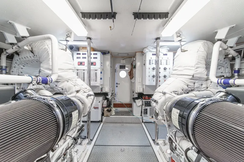 Slide: The Image of Engine room of 2006 Lazzara 84 Flybridge yacht, featuring dual engines and control panels. - 107