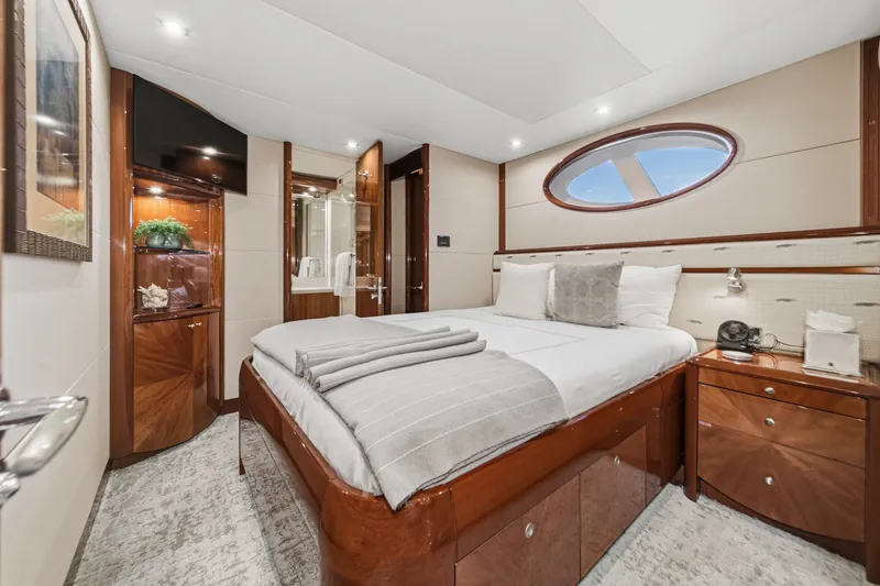Slide: The Image of Luxurious bedroom interior on 2006 Lazzara 84 Flybridge yacht, featuring elegant wood finishes. - 82