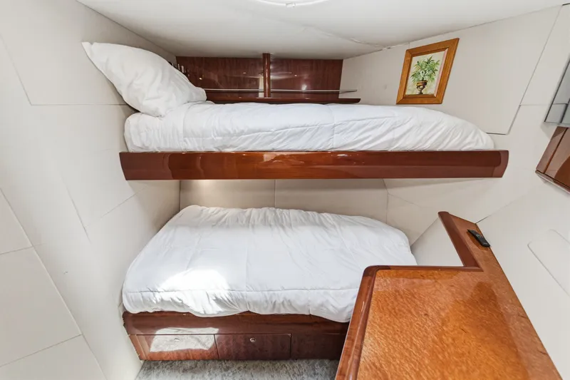 Slide: The Image of Bunk beds in 2006 Lazzara 84 Flybridge yacht cabin, featuring wood accents and framed artwork. - 69