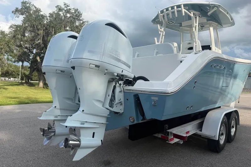 Slide: The Image of 2020 Cobia 301 Center Console boat with dual Yamaha outboard engines on a trailer. - 16