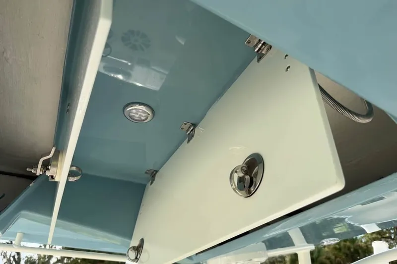 Slide: The Image of 2020 Cobia 301 Center Console storage compartment with latch and light. - 13