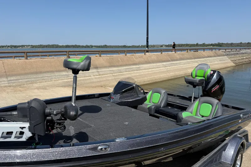 Slide: The Image of 2020 Ranger Z518 boat with green seats docked by a lakeside ramp. - 27