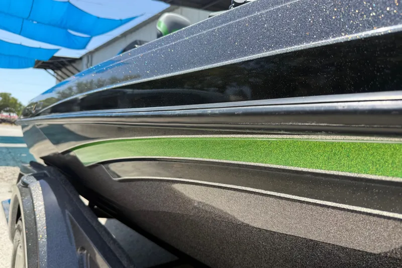 Slide: The Image of 2020 Ranger Z518 boat with sleek black and green detailing under a blue canopy. - 44