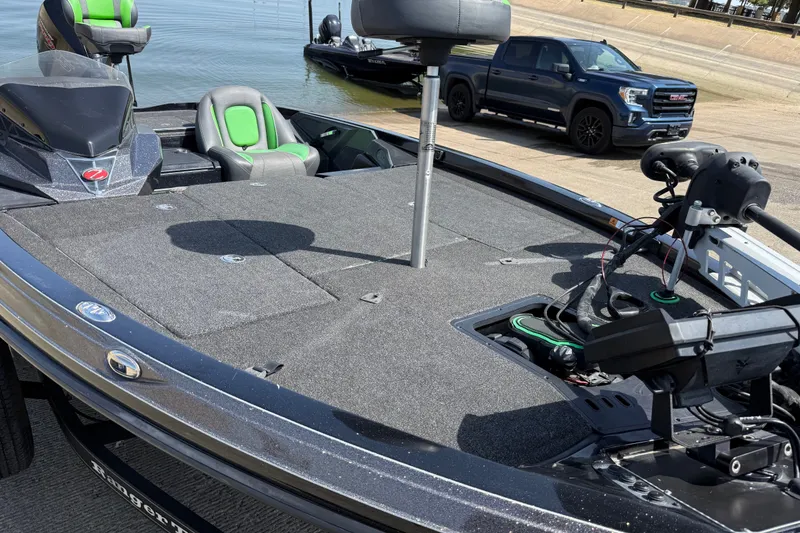 Slide: The Image of 2020 Ranger Z518 boat with green seats, docked near a pickup truck by the water. - 22