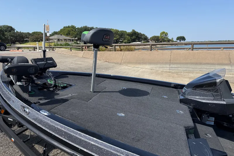 Slide: The Image of 2020 Ranger Z518 boat deck with fishing equipment, parked near a scenic waterfront. - 25