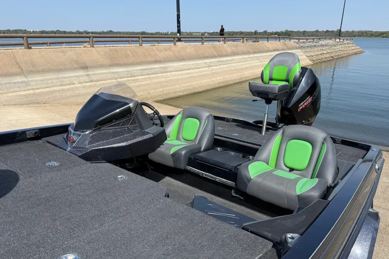 Slide: The Image of 2020 Ranger Z518 boat with green seats, docked by a concrete ramp. - 26