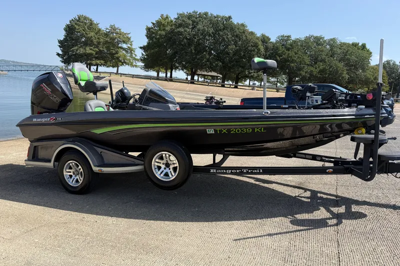 Slide: The Image of 2020 Ranger Z518 boat on trailer by lakeside, featuring sleek design and vibrant accents. - 17