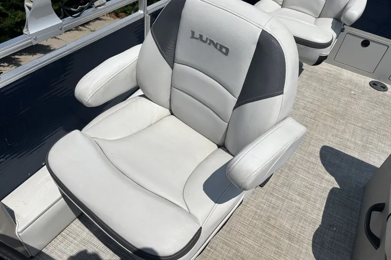 Slide: The Image of 2020 Lund LX220 Pontoon boat seat with gray upholstery and armrests. - 11