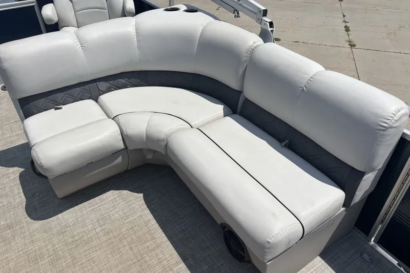 Slide: The Image of 2020 Lund LX220 Pontoon boat with plush, curved seating in light gray upholstery. - 9