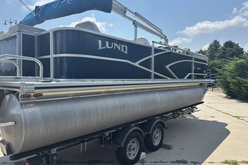 Slide: The Image of 2020 Lund LX220 Pontoon boat on trailer under clear sky. - 4