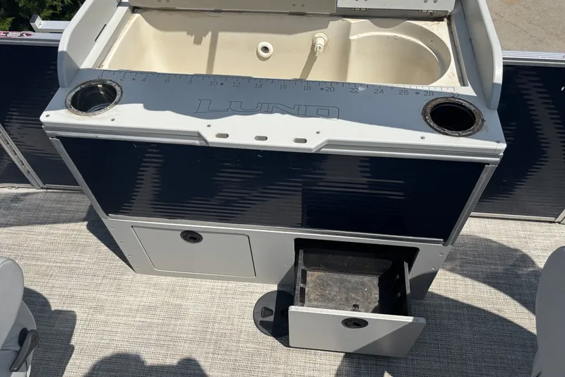 Slide: The Image of 2020 Lund LX220 Pontoon boat sink and storage area with cup holders. - 13
