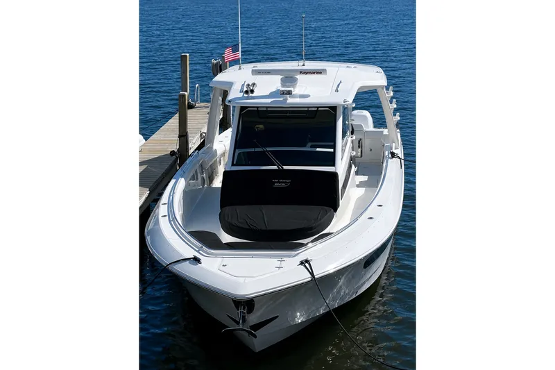 Slide: The Image of 2016 Boston Whaler 420 Outrage docked on calm water, showcasing sleek design and spacious deck. - 3