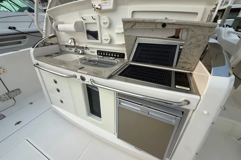 Slide: The Image of 2016 Boston Whaler 420 Outrage boat kitchen with sink, grill, and storage. - 32