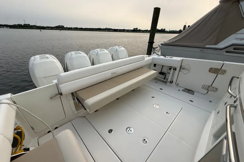 Slide: The Image of 2016 Boston Whaler 420 Outrage boat with multiple outboard engines docked by the water. - 27