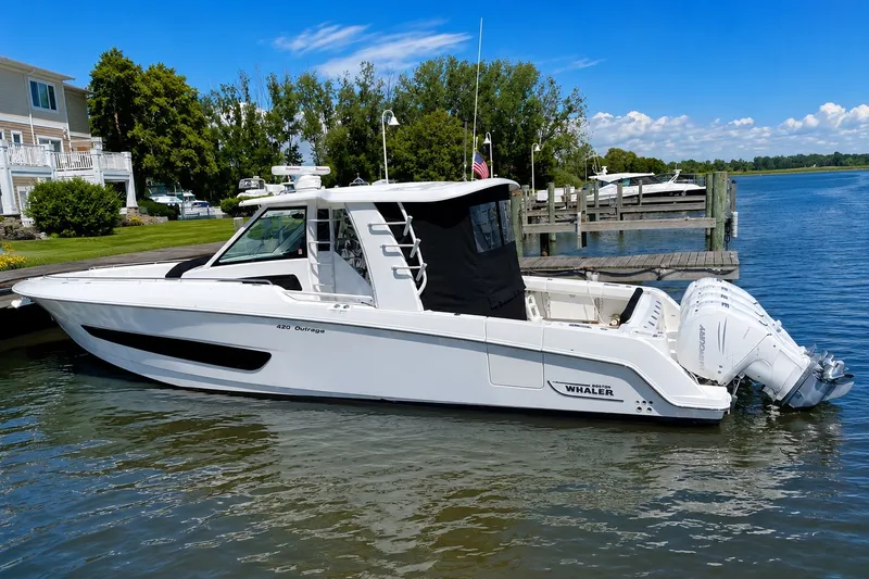 Slide: The Image of 2016 Boston Whaler 420 Outrage docked by a scenic waterfront. - 1