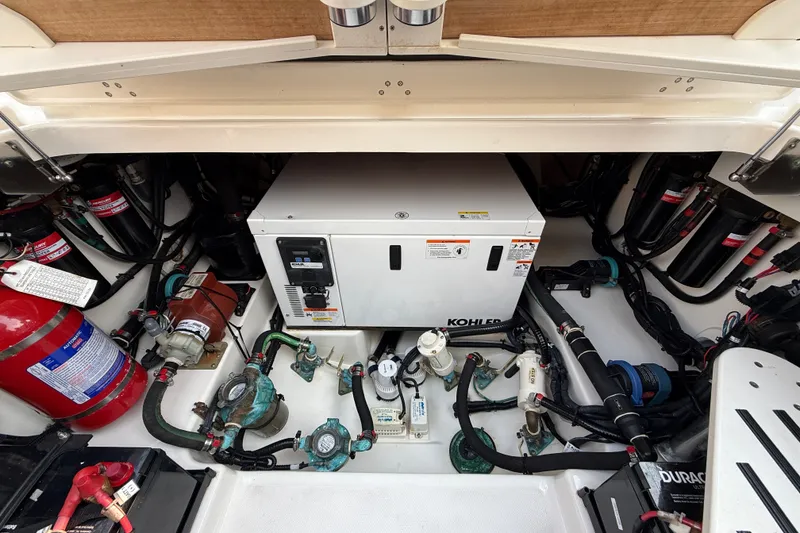 Slide: The Image of Engine compartment of a 2016 Boston Whaler 420 Outrage with Kohler generator and fire extinguisher. - 59