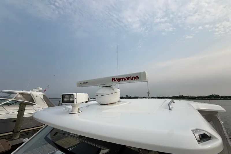 Slide: The Image of Boston Whaler 420 Outrage 2016 with Raymarine radar on deck, docked by the water. - 13