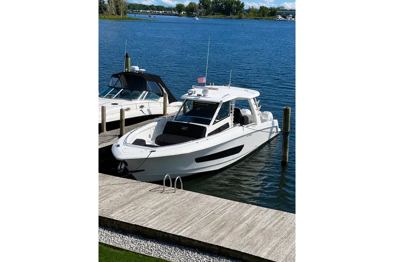 Slide: The Image of 2016 Boston Whaler 420 Outrage docked on a serene lake. - 2