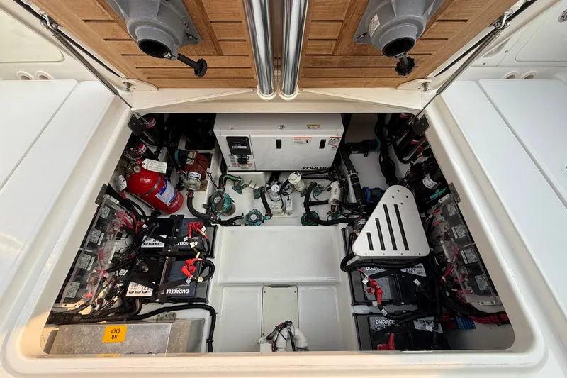 Slide: The Image of Engine compartment of 2016 Boston Whaler 420 Outrage, featuring batteries and fire extinguisher. - 56