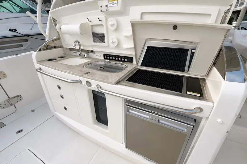 Slide: The Image of Outdoor kitchen on 2016 Boston Whaler 420 Outrage with sink, grill, and refrigerator. - 8