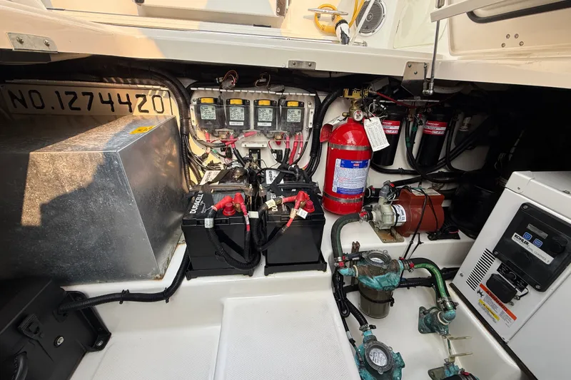 Slide: The Image of Engine compartment of a 2016 Boston Whaler 420 Outrage, featuring batteries and safety equipment. - 60