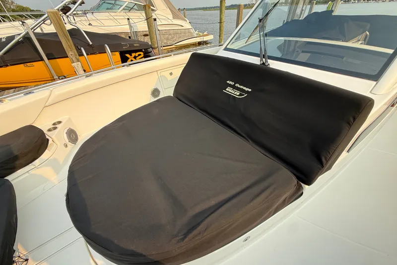 Slide: The Image of 2016 Boston Whaler 420 Outrage boat with cushioned seating, docked near other vessels. - 46
