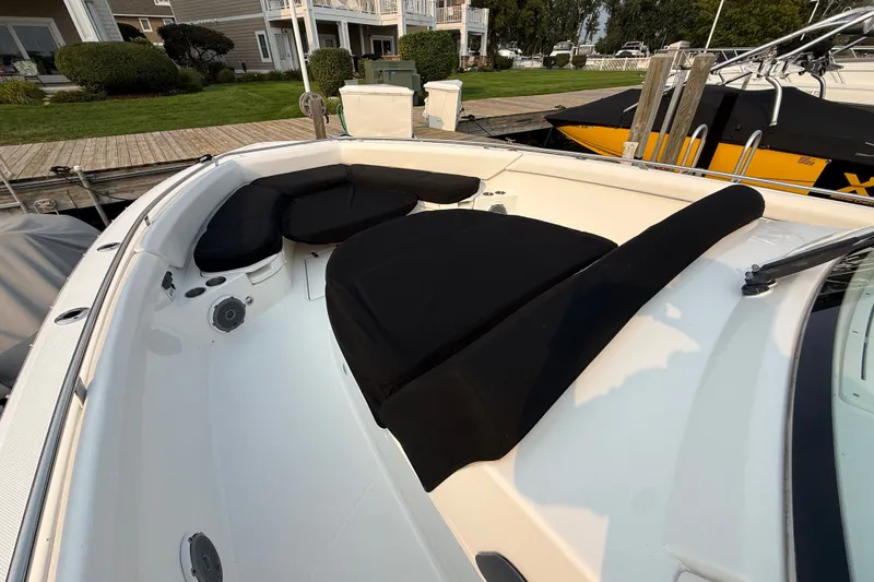 Slide: The Image of 2016 Boston Whaler 420 Outrage boat with cushioned seating at dockside. - 48