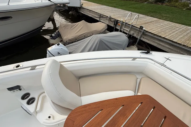 Slide: The Image of 2016 Boston Whaler 420 Outrage boat interior with seating and wooden table, docked by the pier. - 16