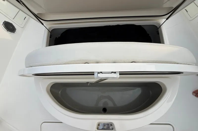 Slide: The Image of 2016 Boston Whaler 420 Outrage storage compartment with open cushioned seat. - 20
