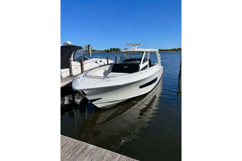 Slide: The Image of 2016 Boston Whaler 420 Outrage docked on calm water under clear blue sky. - 5