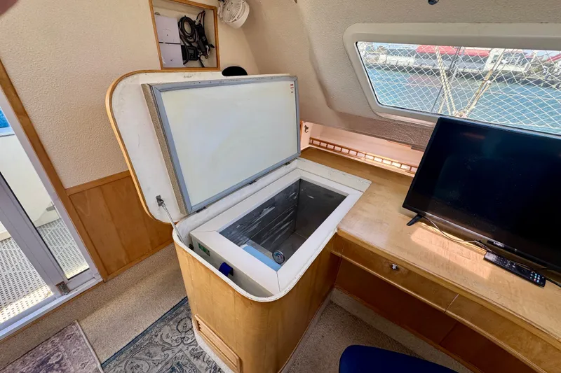 Slide: The Image of Interior of 2000 St Francis 44 yacht with open fridge and TV on wooden desk. - 14