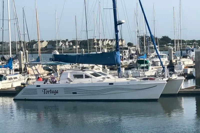 Slide: The Image of St Francis 44 catamaran named "Tortuga" docked in a marina, 2000 model. - 5