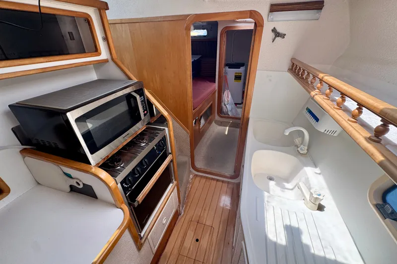 Slide: The Image of Compact kitchen area in a 2000 St Francis 44 yacht, featuring a microwave and sink. - 25