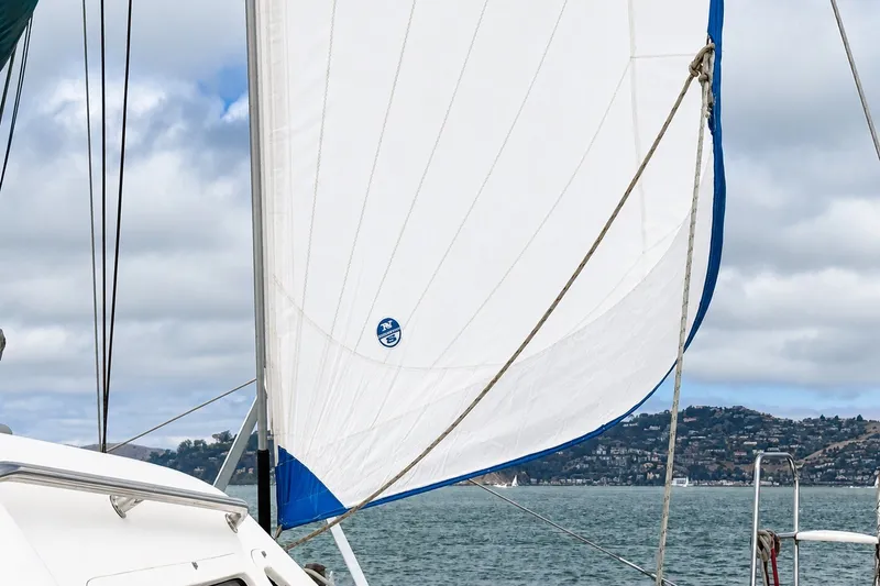 Slide: The Image of Sailboat on water with white sail, St Francis 44, 2000 model, cloudy sky background. - 65