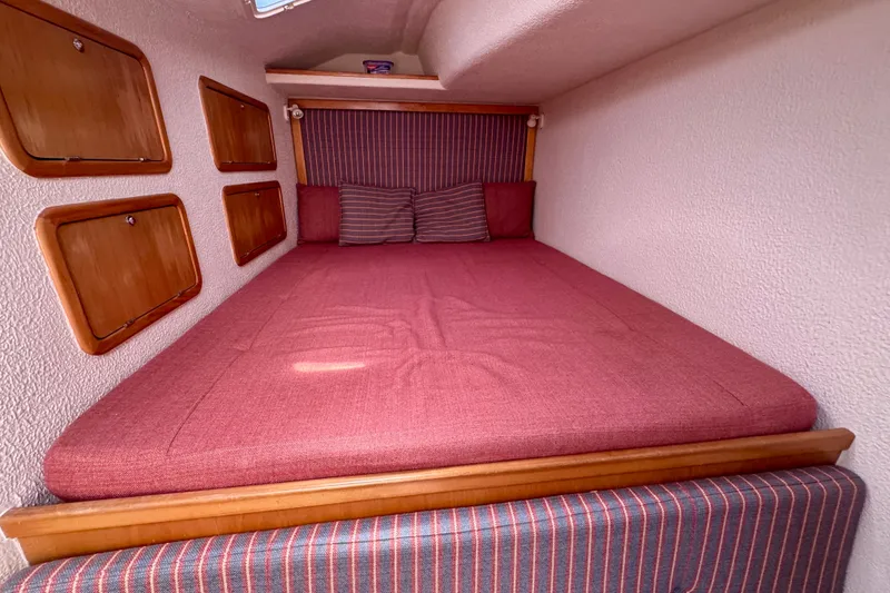 Slide: The Image of Cozy cabin interior of 2000 St Francis 44 yacht with red bedding and wooden storage. - 19